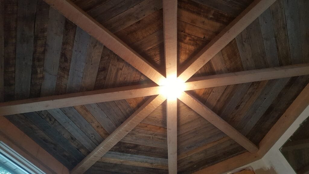 Custom star-pattern ceiling beams with reclaimed wood planking detail