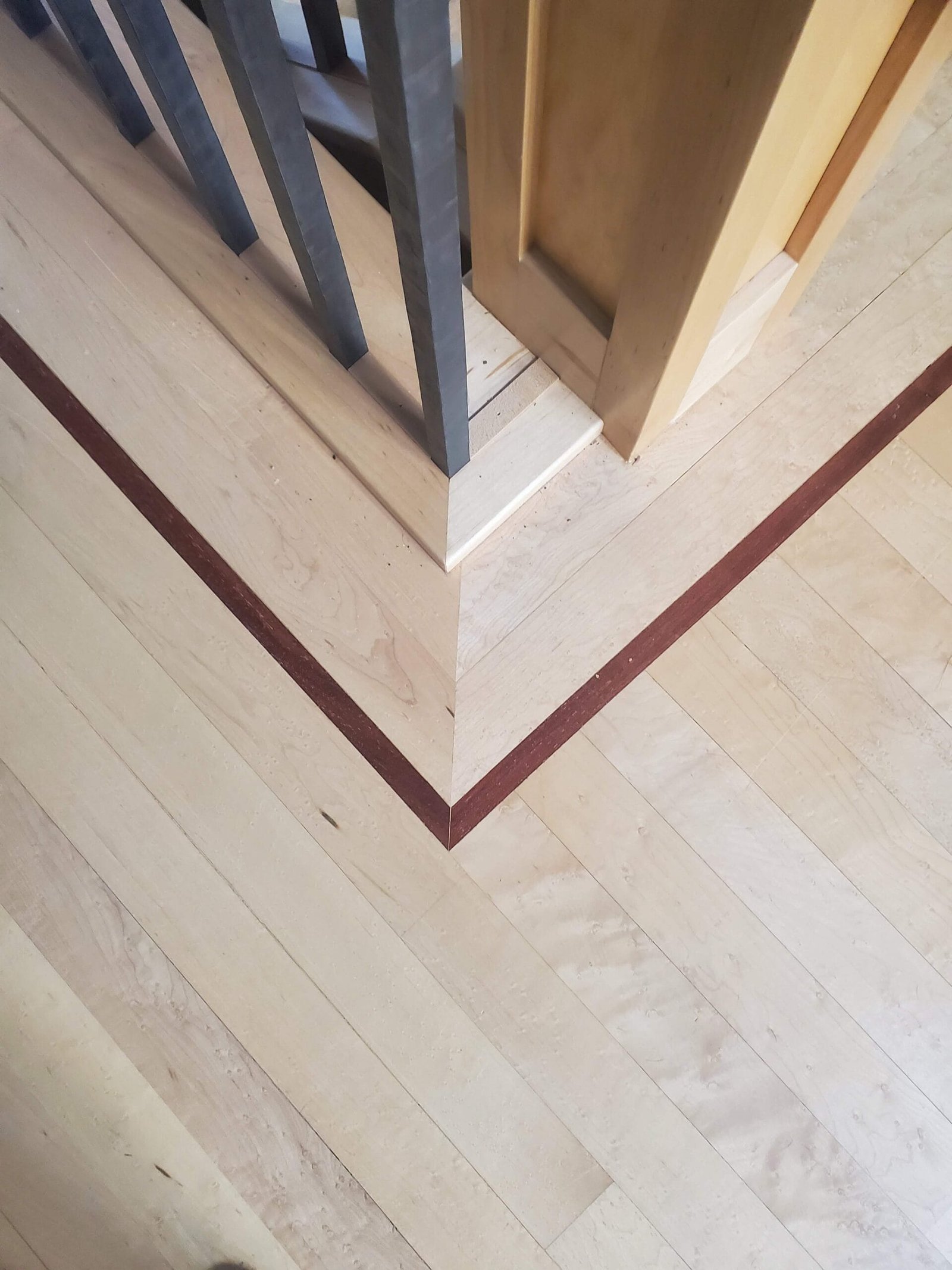 Maple hardwood flooring detail with contrasting cherry inlay border strip