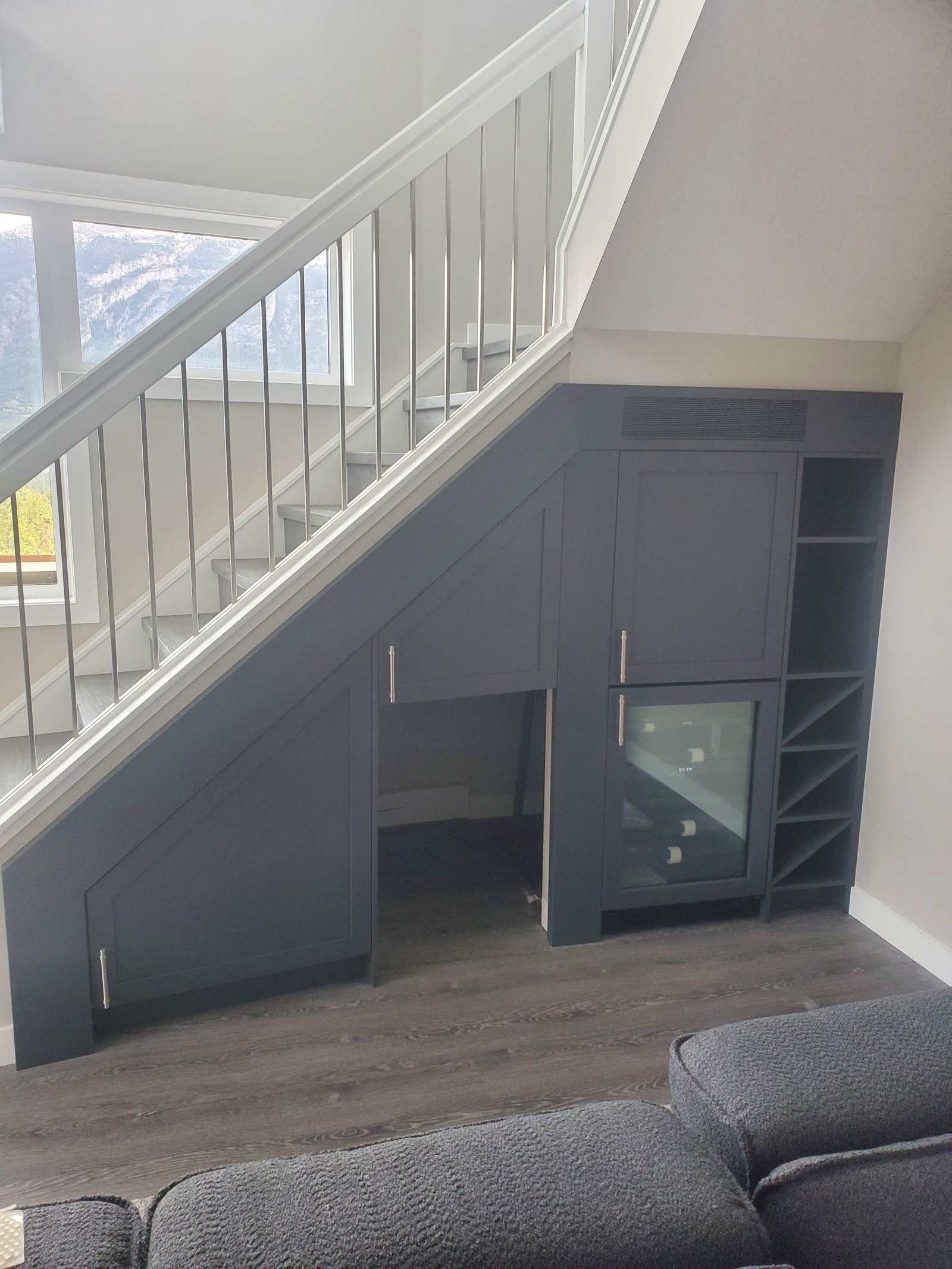 Custom under-stair wine bar and storage cabinetry with beverage fridge