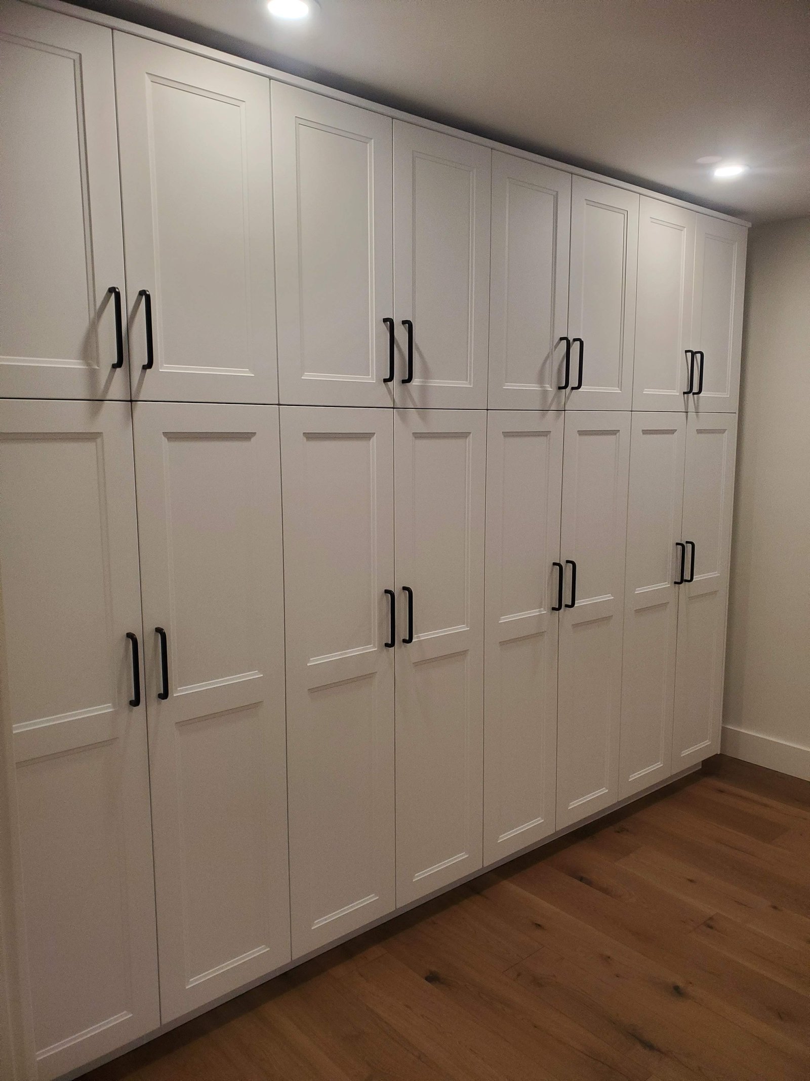 Floor-to-ceiling custom built-in shaker cabinetry with matte black hardware